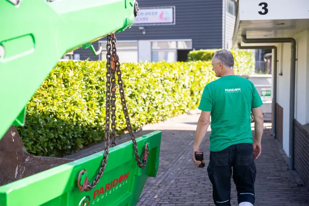 Chaufeur loopt naast container